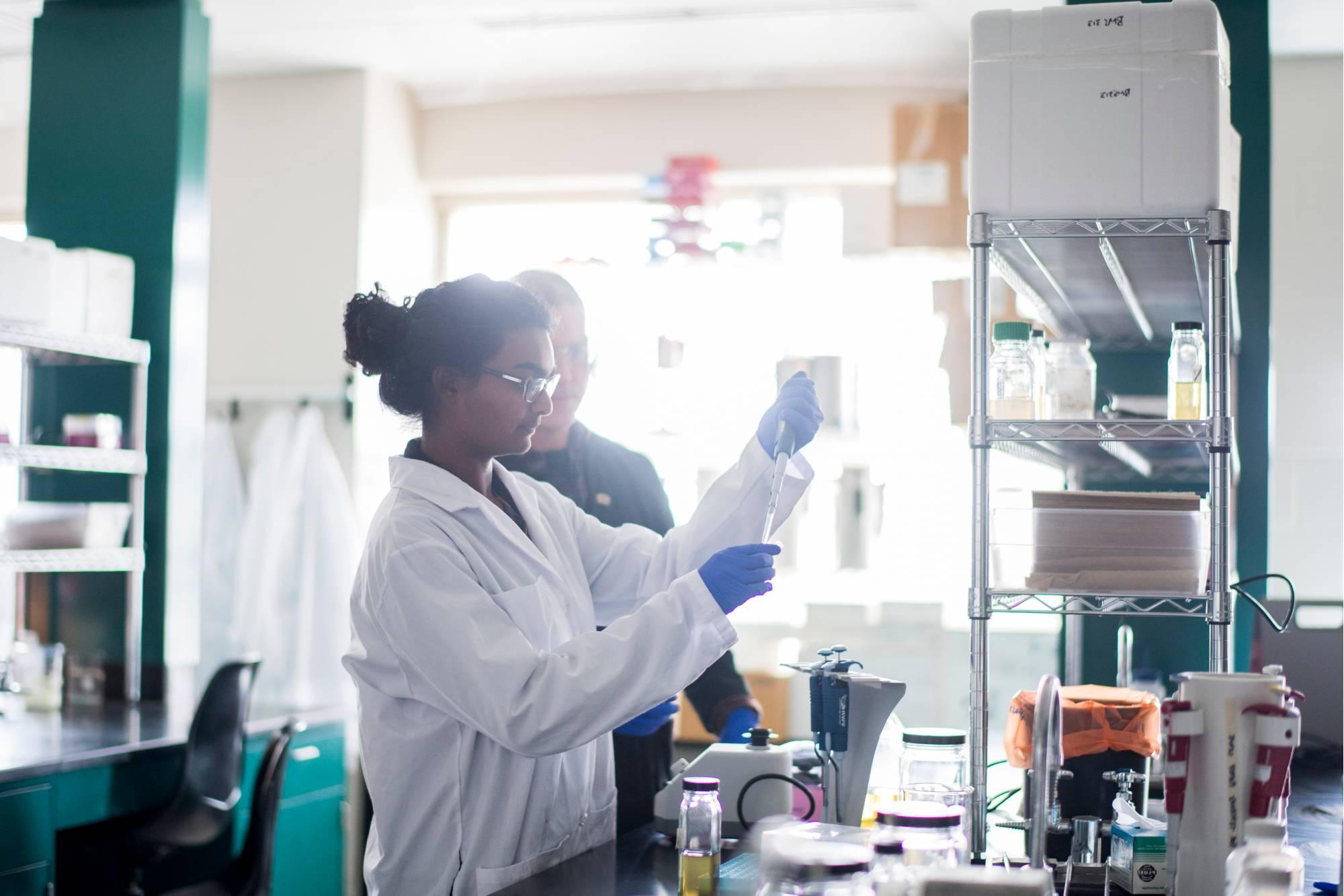A cell and molecular biology student in a GVSU lab working with her professor.